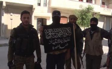 Jabhat Al-Nusra fighters in Syria, brandishing their official flag. 